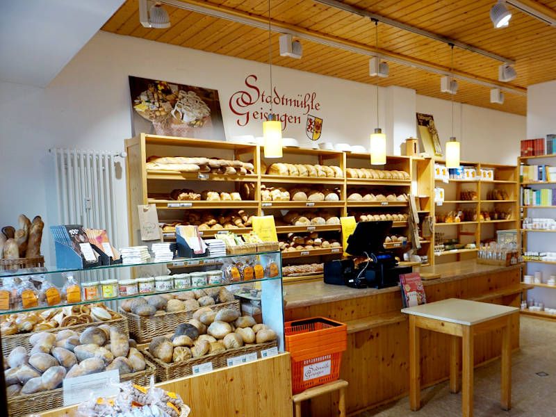 Innenansicht der hellen Filiale Konstanz der Stadtmühle Geisingen mit großer Brottheke und Weinregalen