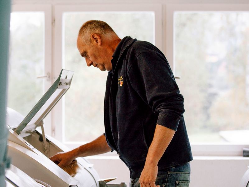 Ein Müller arbeitet in der Stadtmühle Geisingen an einer geöffneten Mahlmaschine