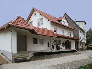 The new building with its red tiled roof, a customer at the shop entrance